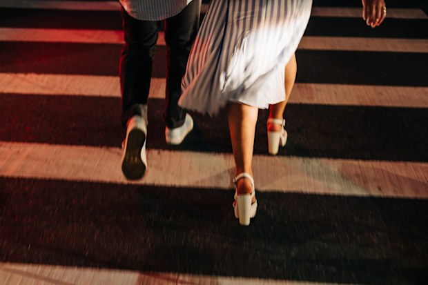 Stock image of a couple's feet as they walk over a crosswalk
