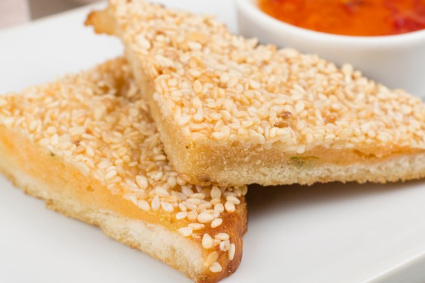 Close up of prawn toast served with chili sauce.