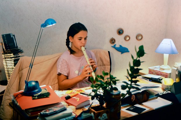 Girl practising her recorder in a 90s bedroom