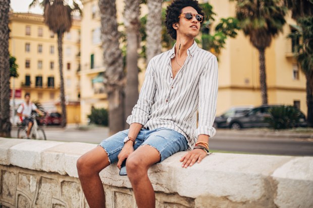 Stock image of a young man wearing denim shorts