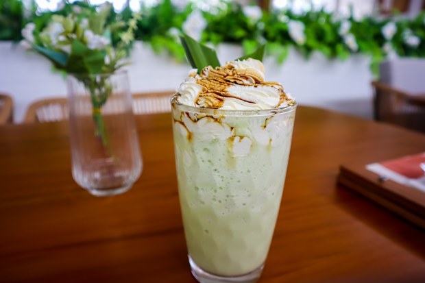 Pandan flavor milkshake with whipped cream and palm sugar topping, sweet and fresh for summer drink