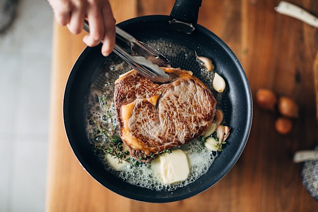 Stock image of a steak being cooked
