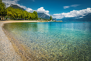 Amazing gravelly beach with clean transparent water in the bay, Toscolano Maderno, Lake Garda, Lombardy, Italy, Europe