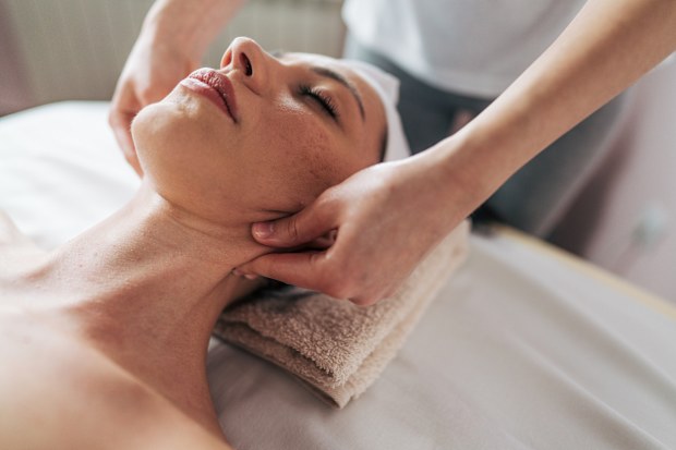 一位年轻女子接受按摩的库存图片