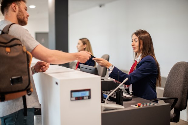 man checking in at an airport with his luggage