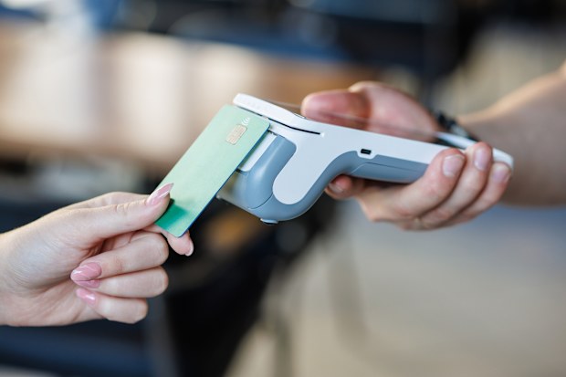 Closeup of a bankcard tapping a wireless POS reader for secure cashless transaction, ideal for fintech, retail and small business promos.