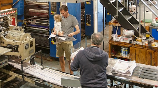 Michael Waite and daughter Hazel at his fledgling newspaper’s printing press. The paper’s motto is “locals helping locals”.