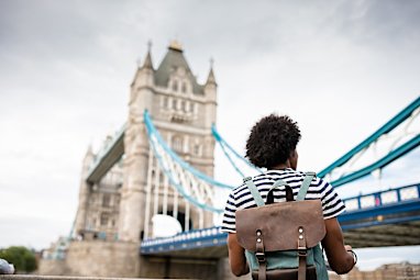 solo traveler in tower bridge area of london reading a map