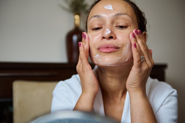 Stock image of a woman applying skincare
