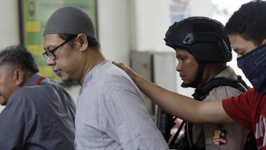 Zainal Anshori, leader of Jemaah Anshorut Daulah, is escorted by police officers at South Jakarta District Court on Tuesday.