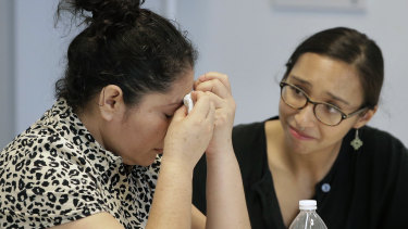 A mother from Guatemala, left, identified only by initials LJ, who was separated from her two children on arrival in May, receives support from translator Brenda Quintana, right.