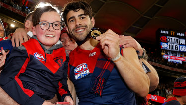 Christian Petracca celebrates with Melbourne fans at Optus Stadium after the grand final.