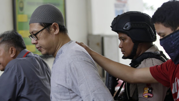 Zainal Anshori, leader of Jemaah Anshorut Daulah, is escorted by police officers at South Jakarta District Court on Tuesday.