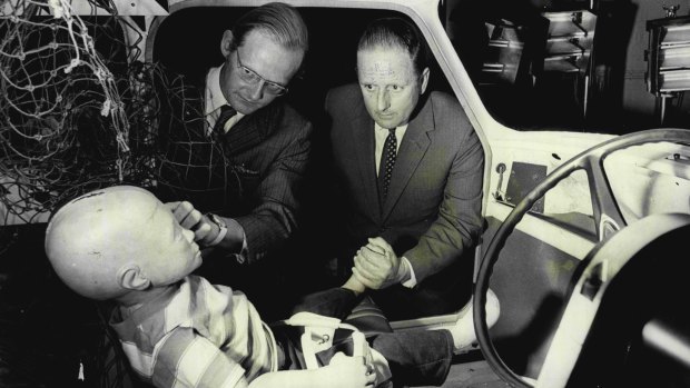 Dr Michael Henderson (left), head of the Traffic Accident Research Unit, shows  Milton Morris a special child dummy after a simulated accident in 1972.