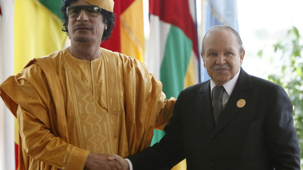 Libyan leader Moammar Gaddafi shakes hand with Bouteflika in 2009.