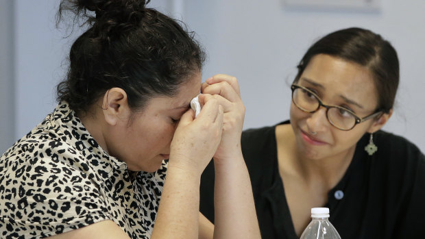 A mother from Guatemala, left, identified only by initials LJ, who was separated from her two children on arrival in May, receives support from translator Brenda Quintana, right.