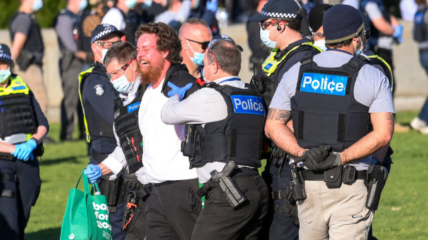 A man is taken away by police at the Shrine of Remembrance. 