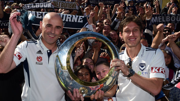 Coach Kevin Muscat and then-skipper Mark Milligan toast Melbourne Victory's 2015 A-League championship with fans following their 3-0 grand final win against Sydney FC.