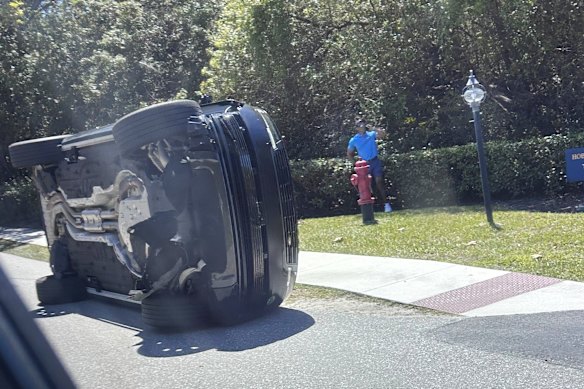 Woods is seen standing next to his overturned Range Rover on Florida's Jupiter Island.