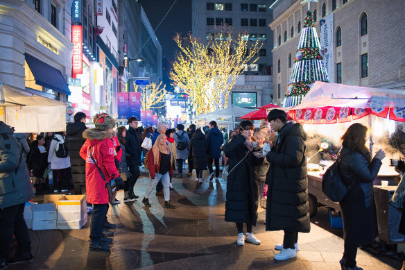 The fashion district Myeong-dong puts on a bustling night-food market during Christmas.