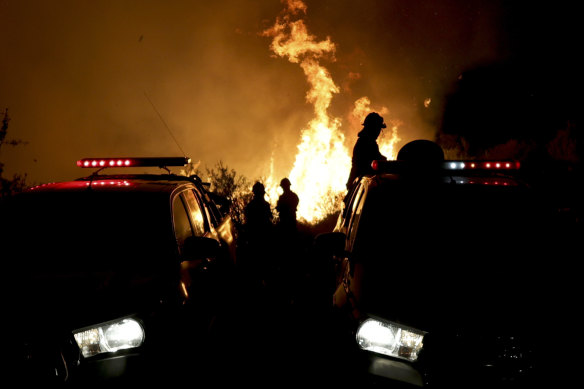 Firefighters work on flames of a forest fire on the outskirts of Villa Carlos Paz.