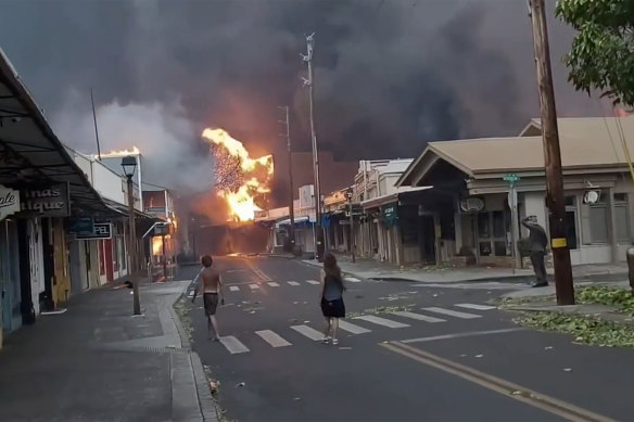 People watch as smoke and flames fill the air from raging fires in West Maui.