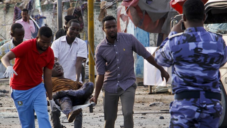 Somalis carry away an injured civilian who was wounded in a bomb blast near the Sahafi hotel in the capital Mogadishu, Somalia.