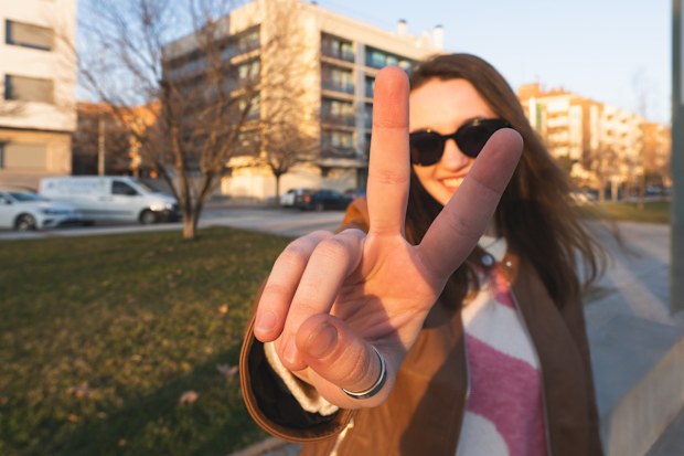 Stock image of a young woman making a peace sign with her fingers
