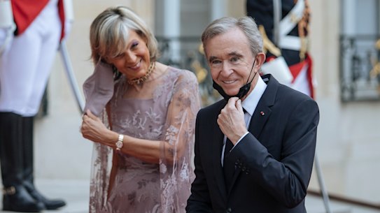 LVMH chief Bernard Arnault, with wife Helene, has been working to make sure his company will stay firmly in his family’s hands.