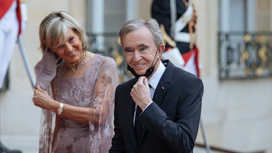 LVMH chief Bernard Arnault, with wife Helene, has been working to make sure his company will stay firmly in his family’s hands.