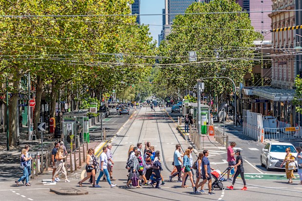 Melbourne, Victoria, Australia, February 12th 2022: Pedestrians are crossing the road at the intersection of Bourke and Spring Streets on a warm sunny day
