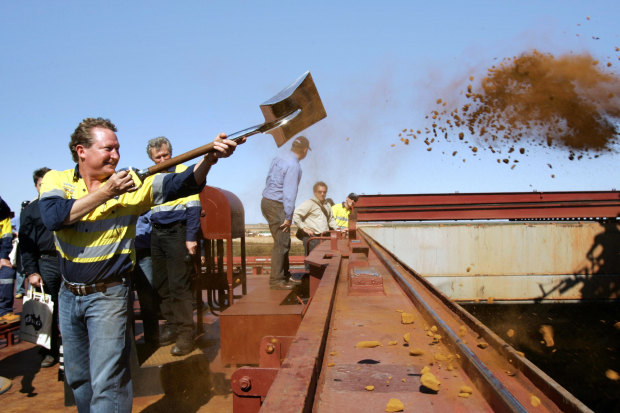 Forrest throws the first shovel-load of iron ore onto a China-bound ship in 2008. 