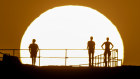 People watch as the sun rises over Ben Buckler Point in Bondi on November 27, 2024 in Sydney, Australia.