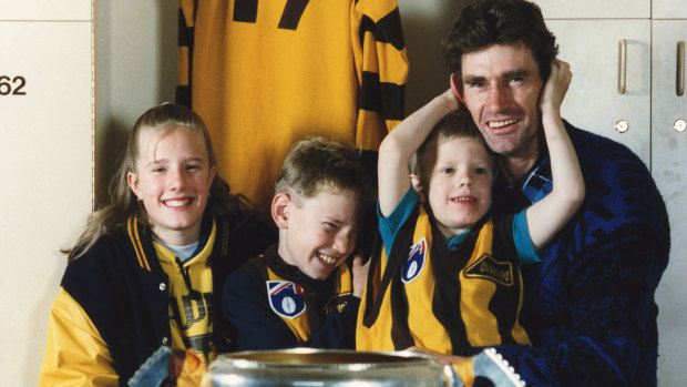 Shane Tuck between siblings Renee and Travis with their father, Hawks great Michael Tuck, in 1991. 