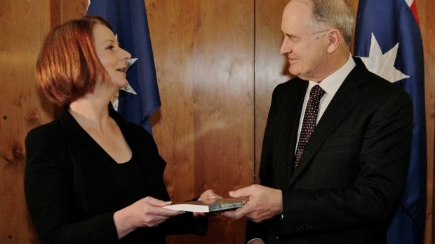 Ross Garnaut presents Julia Gillard with his climate change report in 2011.