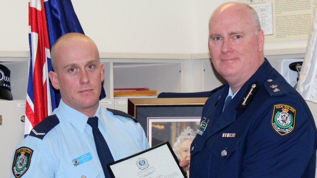 Chris Sheehy (left) receives an award from former Newtown Police commander Simon Hardman.