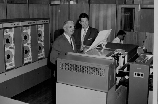 Mr. K. Thomas, chairman of Thomas Nationwide Transport Ltd. (left) and Mr. Barry Z. de Ferranti N.S.W. manager I.C.T. at the official switch-on of the 1902 computer at TNT's Mascot terminal. April 14, 1966.