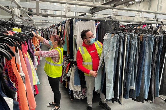 Vinnies Vic online team at work. Kylie Byrne & Chris Pattas with racks of merchandise