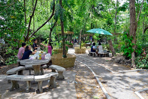 Sun-dappled seating outside Bang Nam Phueng Floating Market.