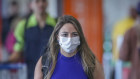 A traveler wears a protect mask while walking through the Juscelino Kubitschek International Airport in Brasilia, Brazil, on Wednesday, March 11, 2020. The World Health Organization was too slow in declaring the global coronavirus outbreak a pandemic, complicating authorities' work to curb the spread of the virus, according to Brazil's Health Minister Luiz Henrique Mandetta. Photographer: Andre Coelho/Bloomberg