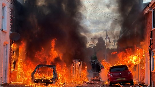 Vehicles set on fire by protesters burn on Lendrick Street in east Belfast, on Tuesday.