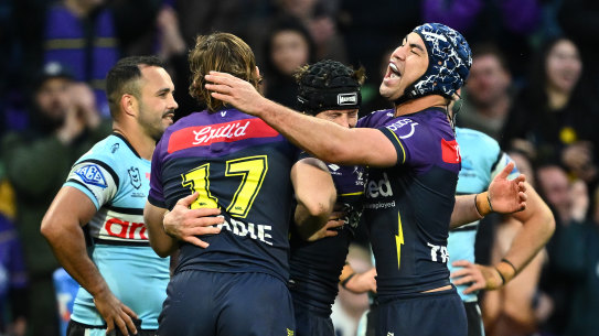 Jahrome Hughes (right) celebrates a Storm try with teammates.