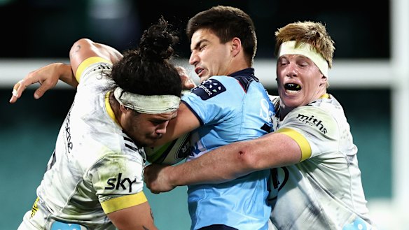 Jack Madocks gets wrapped up by the Hurricanes defence.