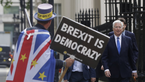 Britain's Conservative MP Michael Fallon passes a demonstrator near the launch of Boris Johnson's leadership campaign in London last week.