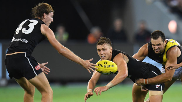 Digging deep: Richmond's Toby Nankervis tackles Carlton's Patrick Cripps as debutant Will Setterfield gets involved.