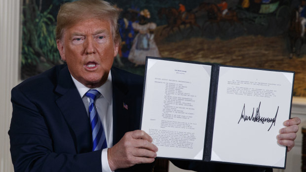 President Donald Trump shows a signed memorandum to pull out of the Iran nuclear deal.