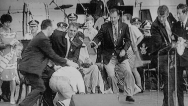 From left: A policeman, then-NSW Premier John Fahey and Ian Kiernan rush to subdue an attacker as Prince Charles is ushered away by  security during an event at Darling Harbour in 1994.