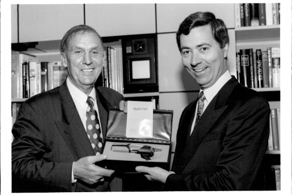 Sydney’s King of morning radio, 2UE’s John Laws (left) gets the ultimate gift - his own gold microphone from Chairman of radio 2UE, Mr. John Conde. March 19, 1993. 