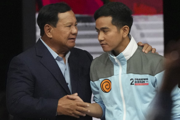 Prabowo shakes hands with his running mate Gibran, the eldest son of Jokowi, at the end of a televised vice presidential candidates’ debate.