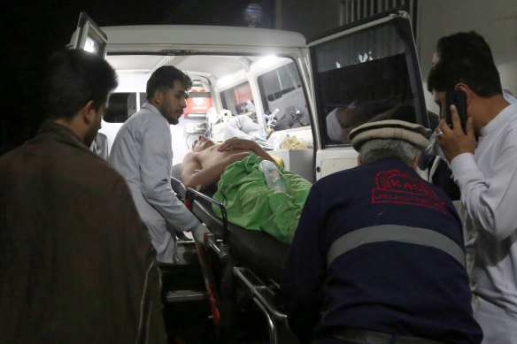 A wounded man is carried to a hospital after the explosion ripped through a wedding hall on a busy Saturday night in Afghanistan's capital.
